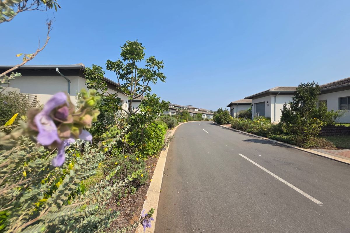 A view of the residential street within the estate, featuring paved roads, manicured verges, and surrounding residential properties.