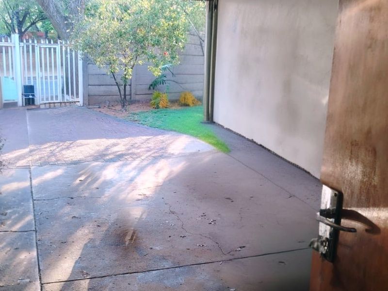 A functional garage space featuring a sectional door, concrete flooring, and direct access to the exterior driveway area.