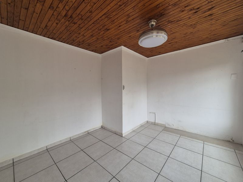 A vacant utility space featuring ceramic floor tiles and a timber tongue and groove ceiling, equipped with plumbing connections for laundry appliances.