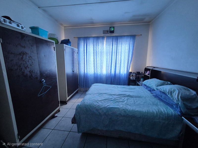 A bedroom featuring tiled flooring and curtain rails, showing signs of ceiling water damage and wear.