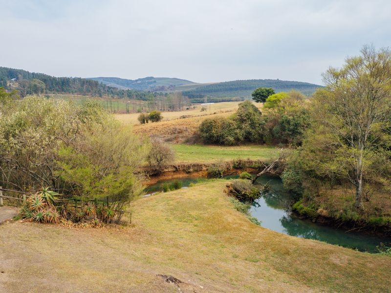 A scenic view of the natural landscape featuring a winding river and rolling hills on the small holding property.