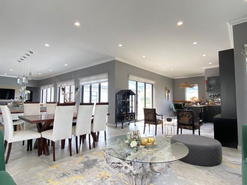 Spacious open-plan living and dining area featuring modern tiled floors, recessed lighting, and seamless access to the outdoors through large sliding glass doors.