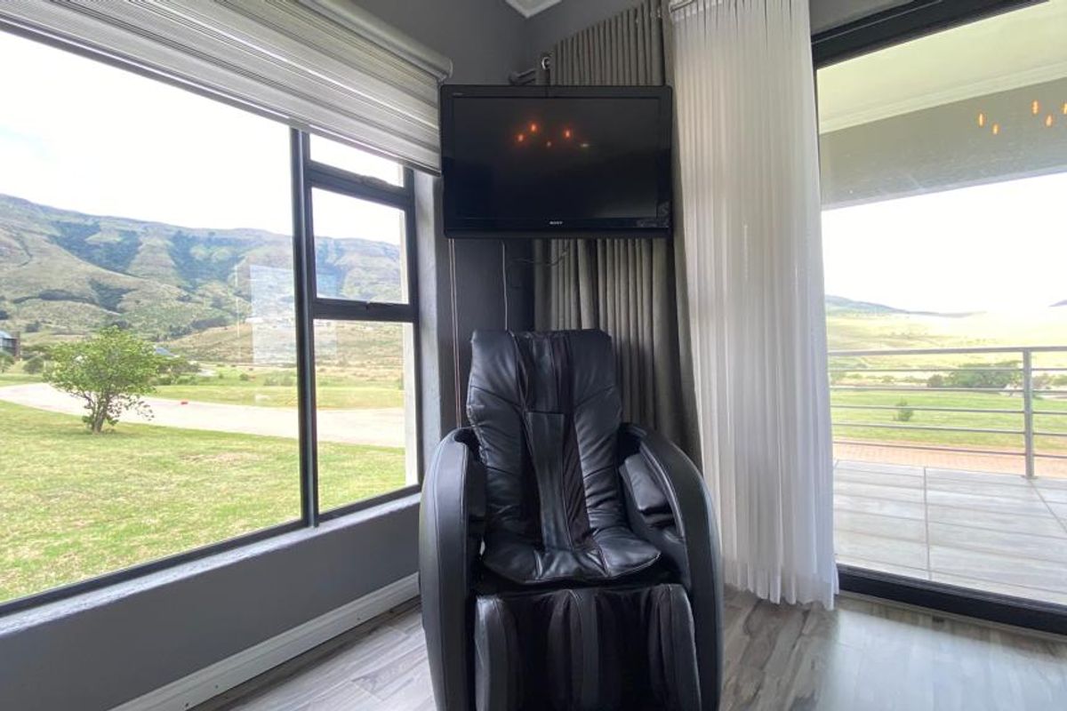 A bright living area featuring large windows and sliding glass doors that offer expansive views of the surrounding landscape and patio.