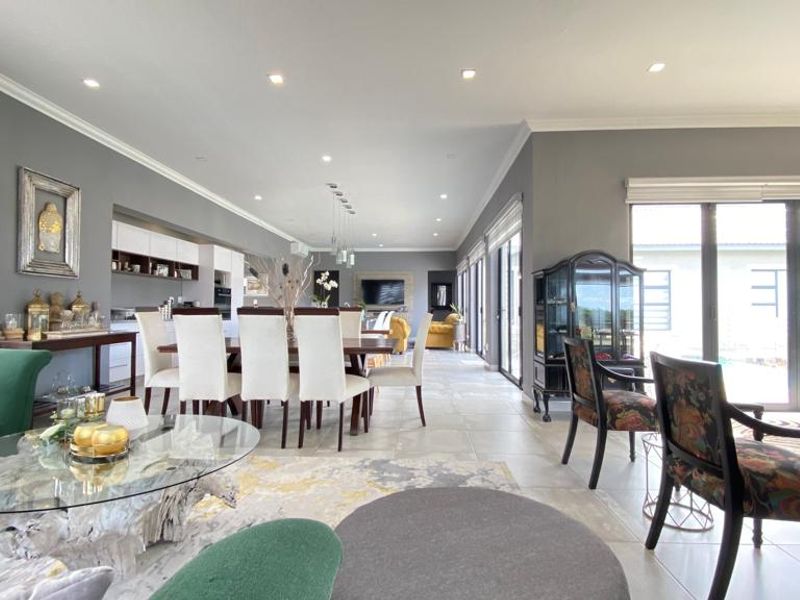 Spacious open-plan living and dining area featuring tiled floors, recessed lighting, and large sliding glass doors providing seamless access to the outdoor space.