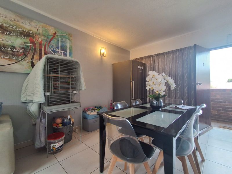 Open plan living and dining area featuring tiled flooring and access to an outdoor balcony.