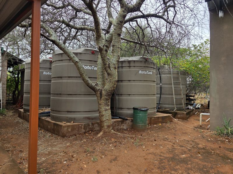 Outdoor utility area featuring multiple large RotoTank water storage tanks mounted on concrete plinths.