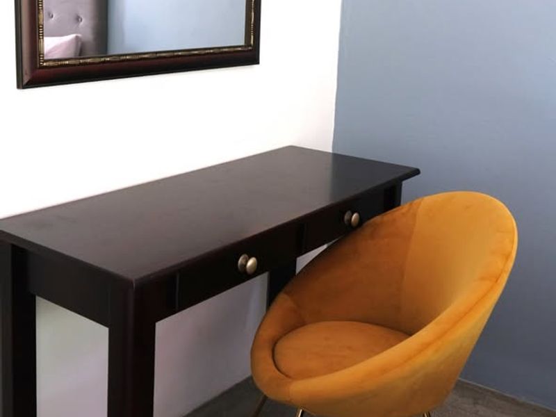 A bedroom corner featuring a desk area with a light switch on a painted accent wall.