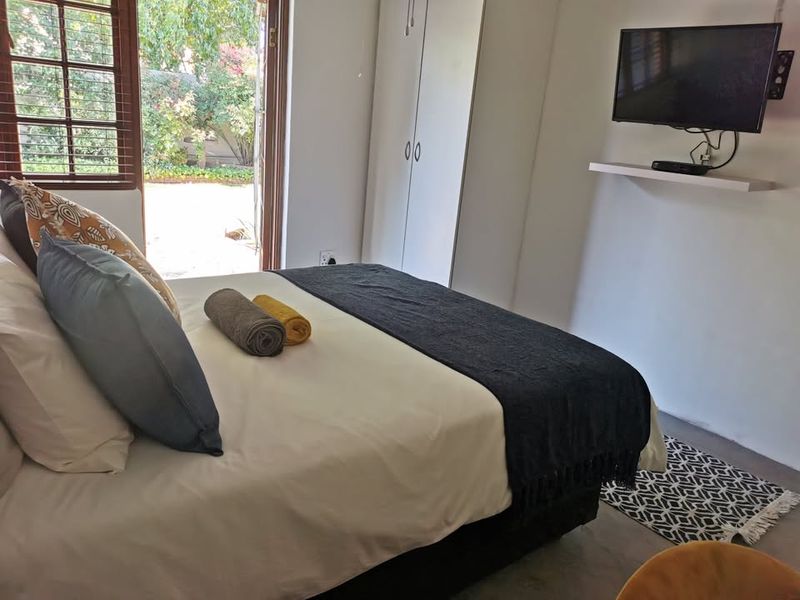 A bedroom featuring built-in wardrobes and french doors providing direct access to the garden area.