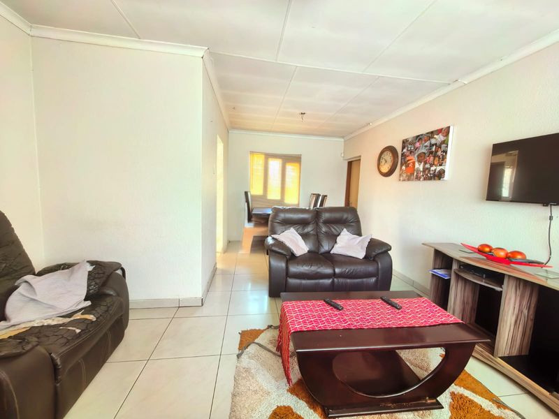 A living room featuring tiled flooring and a coved ceiling, providing a functional and open living space.