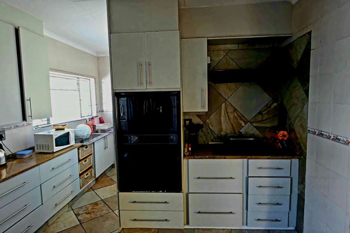 A functional kitchen featuring built-in cabinetry, integrated oven, extractor fan, and tiled splashbacks with ample counter space.
