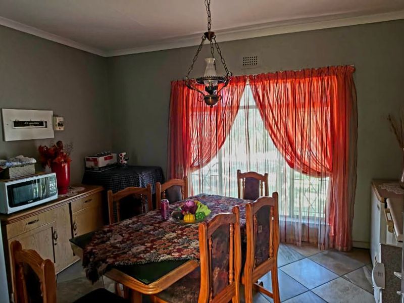 A functional dining room featuring tiled flooring and a central light fixture, providing a practical space for family meals.