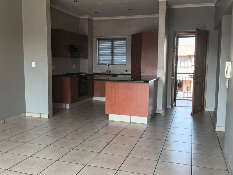 Open plan kitchen and living area featuring tiled flooring, built-in cabinetry, and direct access to a balcony.