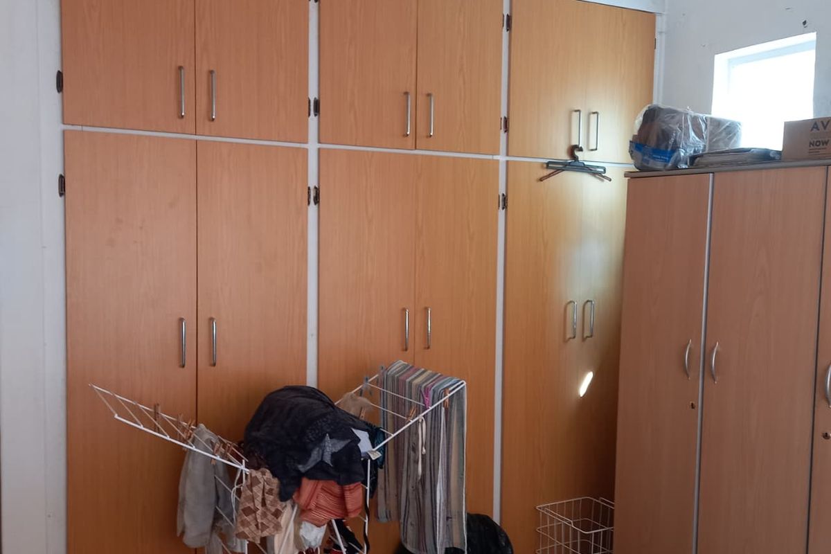 Bedroom featuring extensive floor-to-ceiling built-in wooden cabinetry and wardrobes providing ample storage space.
