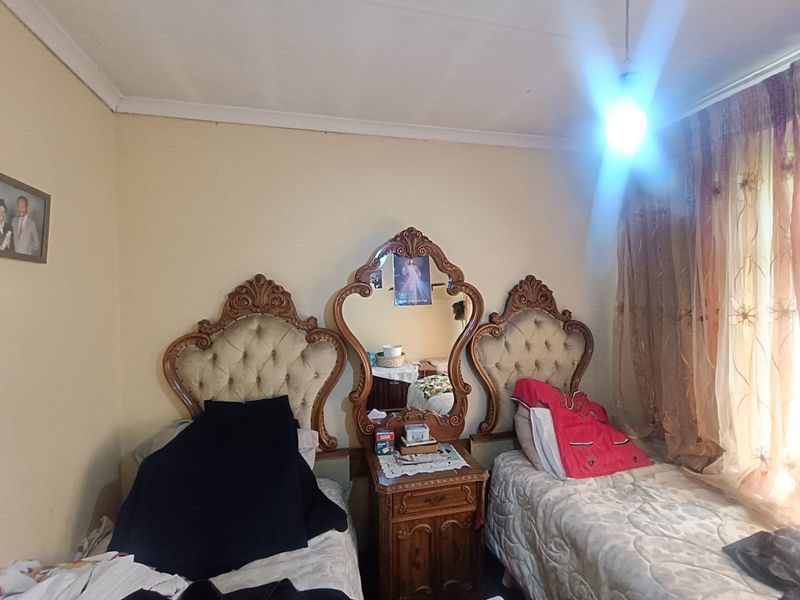 A bedroom featuring standard wall finishes, coving, and window treatments.
