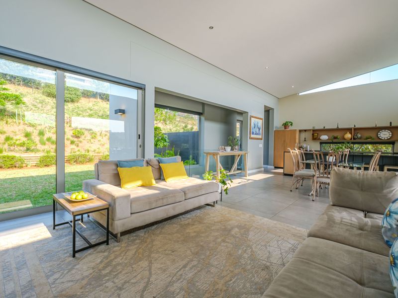 Spacious open-plan living and dining area featuring large sliding glass doors that provide seamless access to the garden and abundant natural light.
