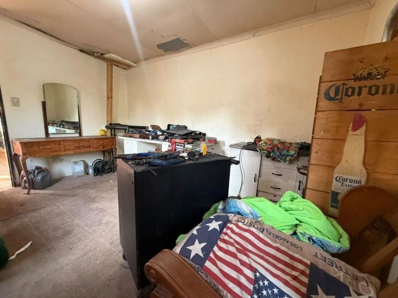 A utility or storage space featuring built-in cabinetry, currently in need of significant cosmetic repair and refurbishment to improve its condition.