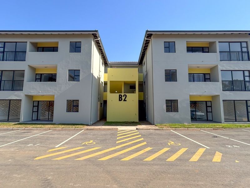Front elevation of a modern apartment building block featuring designated parking bays and private balconies.