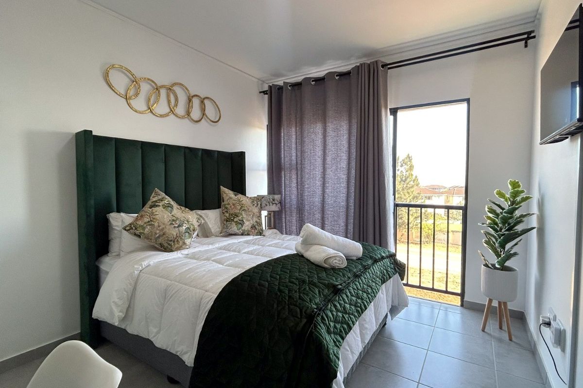 A well-maintained bedroom featuring tiled flooring and direct access to a private balcony through a glass door.