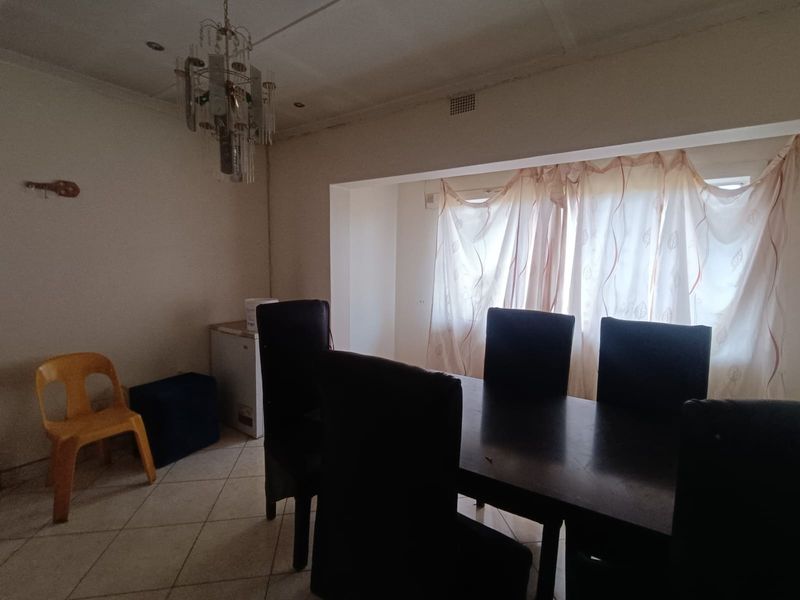 Dining room featuring tiled flooring, recessed lighting, and a decorative chandelier, requiring cosmetic updates to the ceiling and overall finishes.