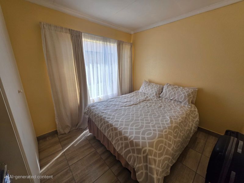 A functional bedroom featuring tiled flooring, a built-in cupboard, and natural light through large windows with curtain rails.