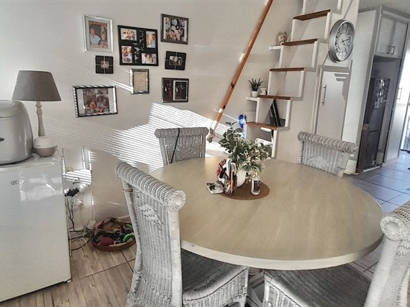 Open plan living and dining area featuring tiled flooring and a staircase leading to an upper level.