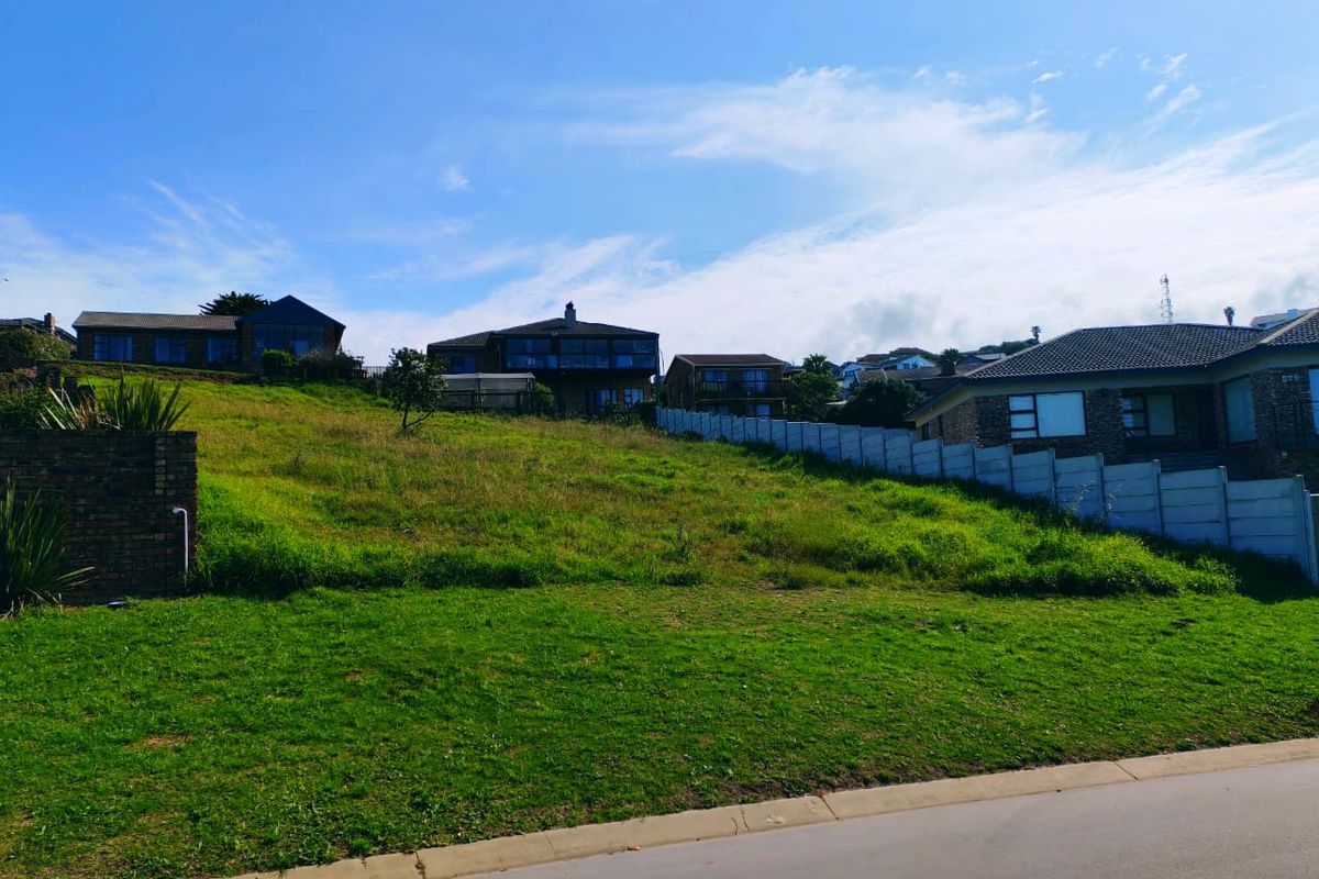 A vacant residential plot featuring a gentle slope, established grass, and existing boundary walling, situated in a developed neighbourhood.