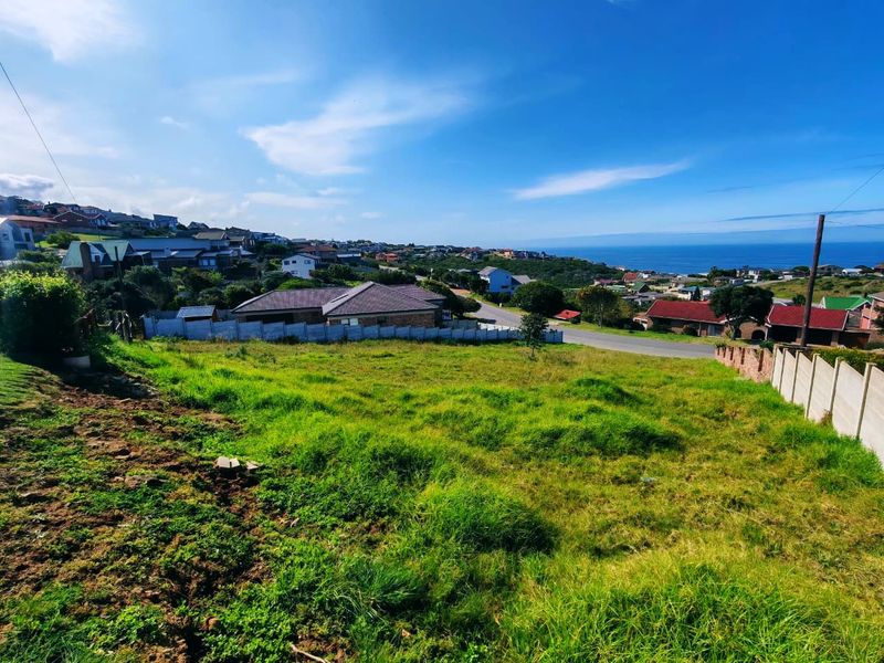 A vacant residential plot featuring a gentle slope, enclosed by precast concrete boundary walls, offering scenic coastal and neighbourhood views.