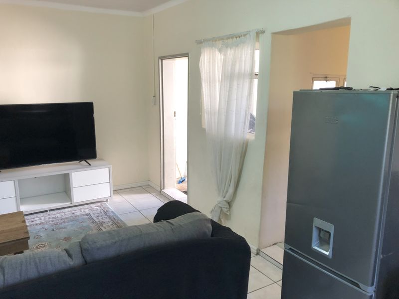 A functional living room area featuring tiled flooring and neutral wall finishes, providing a practical space for daily living.