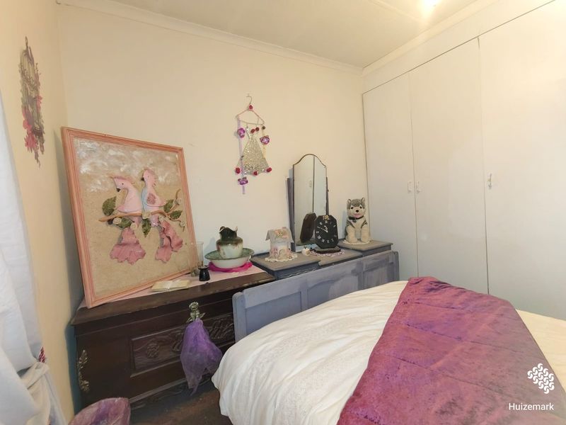 A bedroom featuring built-in cupboards and neutral wall finishes, providing a functional space for rest.