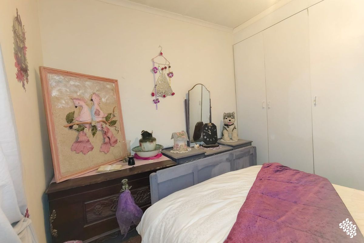 A bedroom featuring built-in cupboards and neutral wall finishes, providing a functional space for rest.