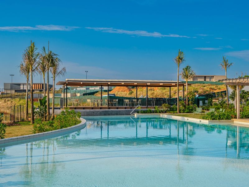 A well-maintained swimming pool area featuring a covered patio structure and landscaped surroundings, ideal for outdoor recreation.