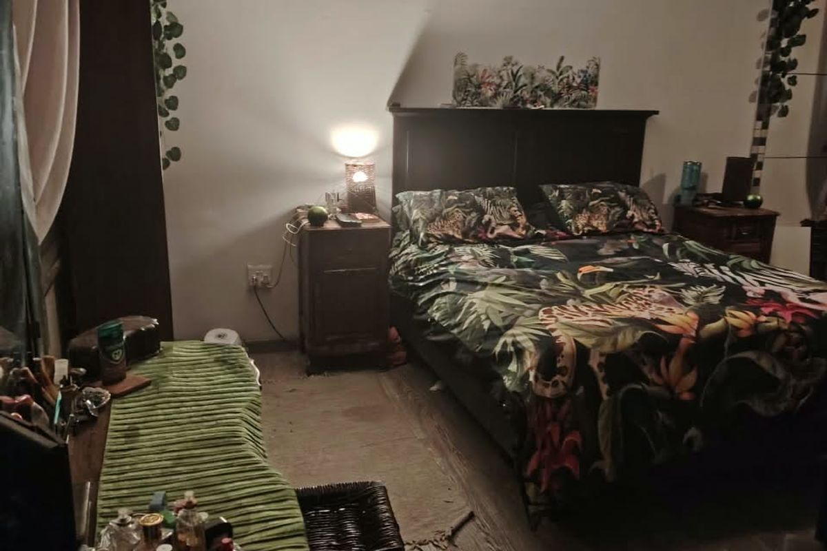 A bedroom featuring a ceiling fan and wood-look flooring, providing a functional sleeping space.