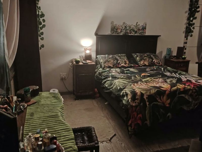 A bedroom featuring a ceiling fan and wood-look flooring, providing a functional sleeping space.