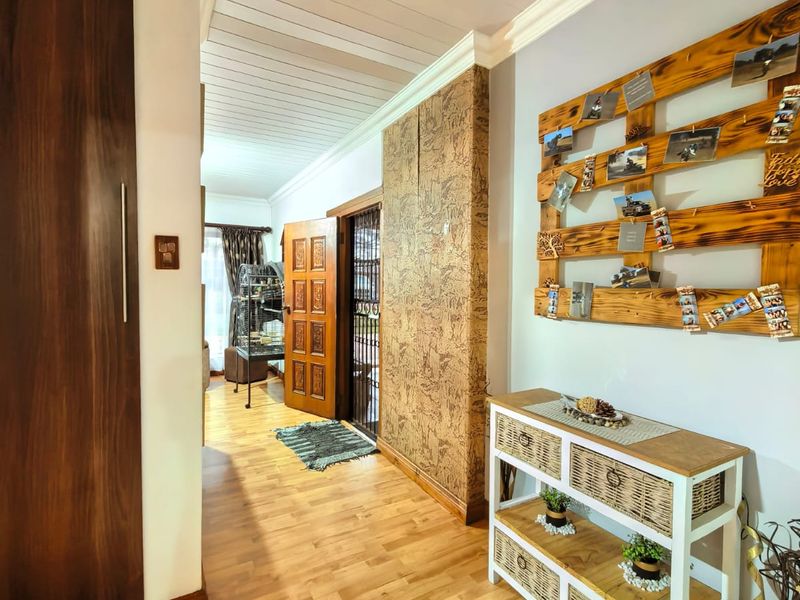 A well-maintained hallway featuring laminate flooring, timber ceiling panels, and built-in cabinetry, providing a warm and inviting transition between living spaces.