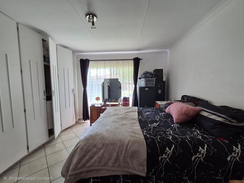 A bedroom featuring built-in cupboards, tiled flooring, and a window with natural light.