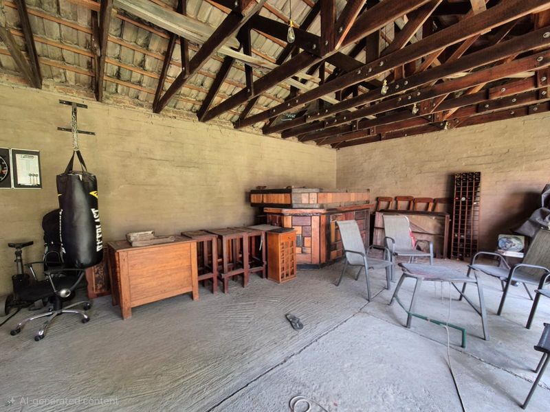 A rustic utility space featuring exposed timber roof trusses, raw brick walls, and a concrete floor, offering potential for conversion or workshop use.