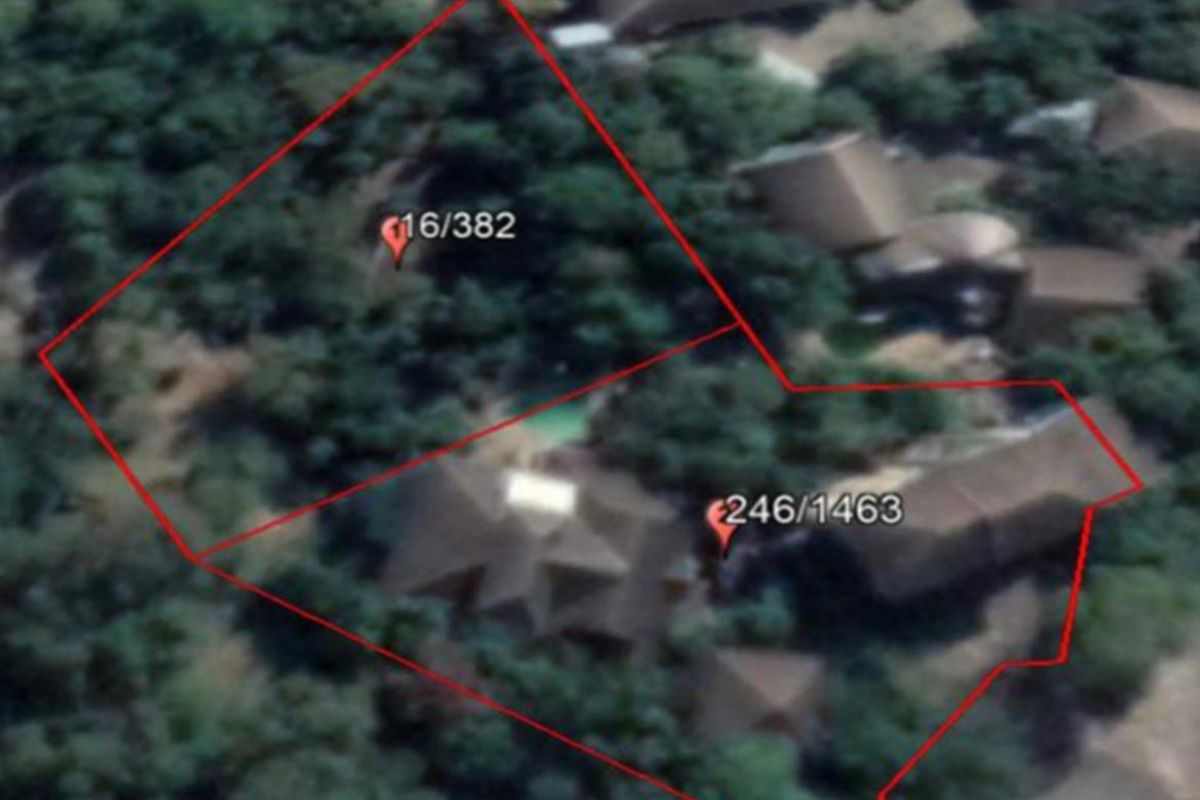 Aerial view of the property showing the site layout, surrounding vegetation, and swimming pool area.