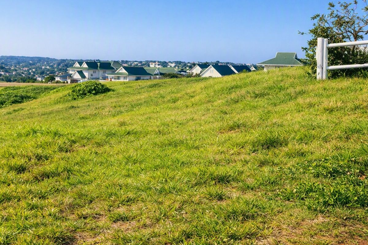 A view of the surrounding residential landscape from the vacant land, featuring a post and rail fence boundary.
