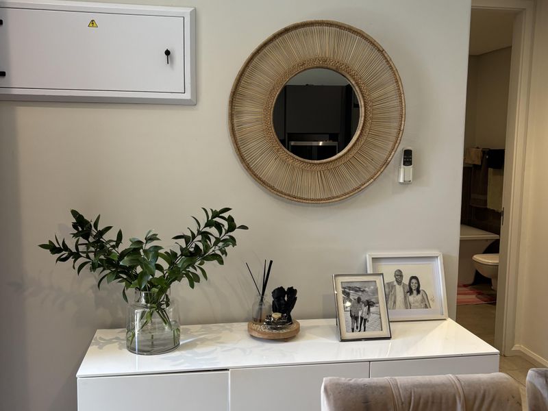 A well-maintained hallway area featuring a wall-mounted electrical distribution board and recessed ceiling lighting, providing a clean and functional transition space.