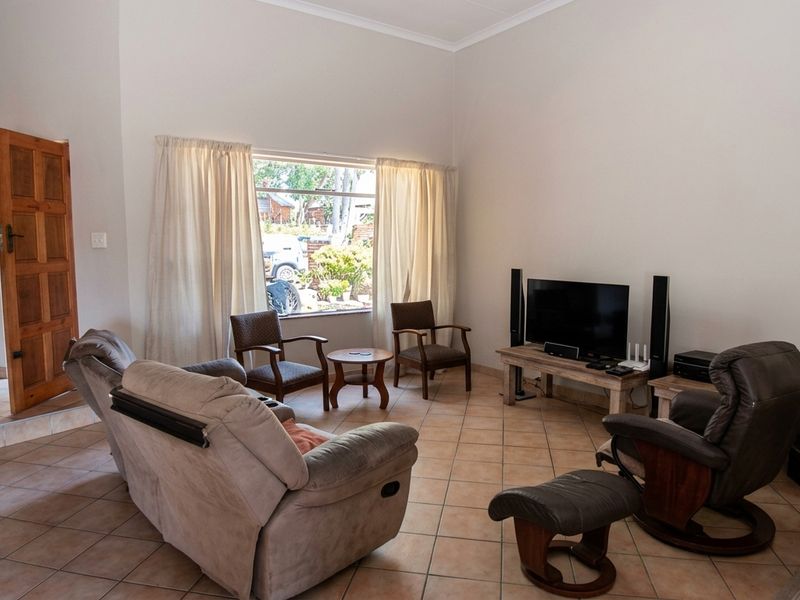 A spacious living room featuring tiled flooring, a large window for natural light, and a built-in freestanding fireplace.