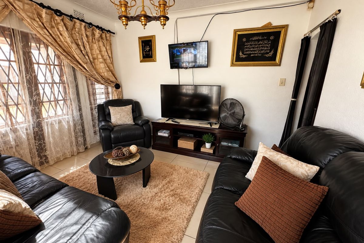A comfortable living room featuring tiled flooring and security bars on the windows, providing a functional and lived-in space.
