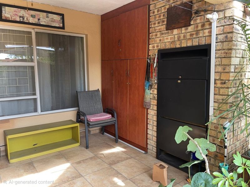 Covered patio area featuring a built-in braai, tiled flooring, and integrated storage cabinetry, providing a functional outdoor entertainment space.