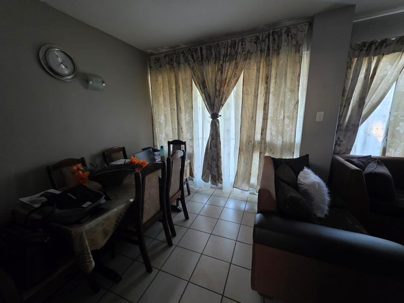 Open plan living and dining area featuring tiled flooring and large sliding glass doors providing access to the exterior.