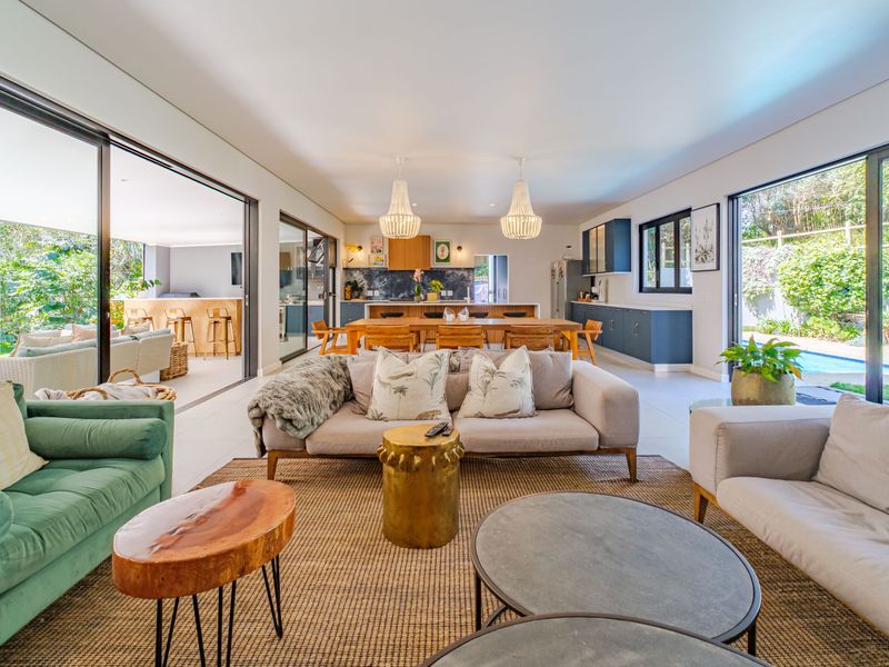 Spacious open-plan living and kitchen area featuring large sliding glass doors, modern cabinetry, and seamless indoor-outdoor flow to the patio and pool.
