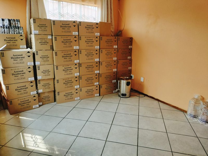 A utility space featuring tiled flooring and neutral wall finishes, currently utilized for storage.