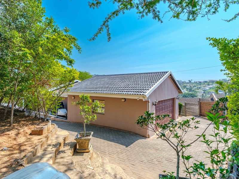 A well-maintained detached garage with a tiled roof, paved driveway, and landscaped surroundings, offering a clean and functional exterior appearance.