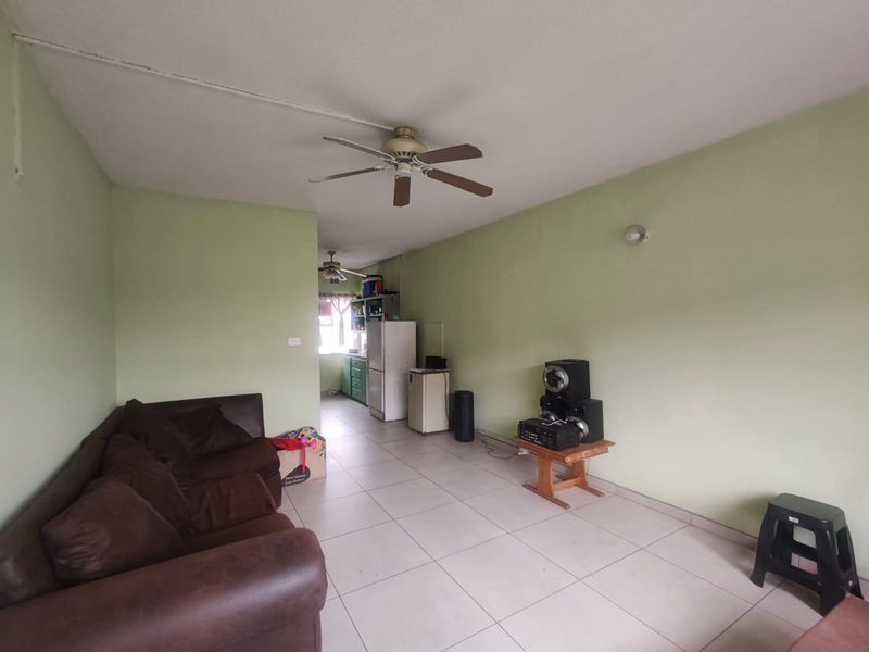 Open plan living and kitchen area featuring tiled flooring and ceiling fans, offering a functional layout with potential for cosmetic updates.