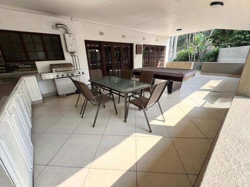 Spacious covered patio featuring tiled flooring, built-in cabinetry, and direct access to the interior through multiple sets of french doors.