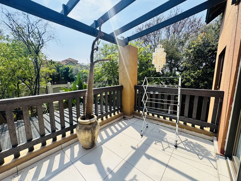 A spacious balcony featuring a timber pergola, tiled flooring, and a timber balustrade, offering an open outdoor area.