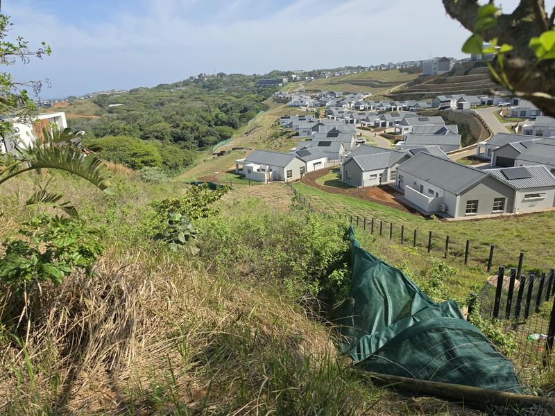 Elevated view overlooking a residential estate development with sloped terrain and surrounding natural landscape.